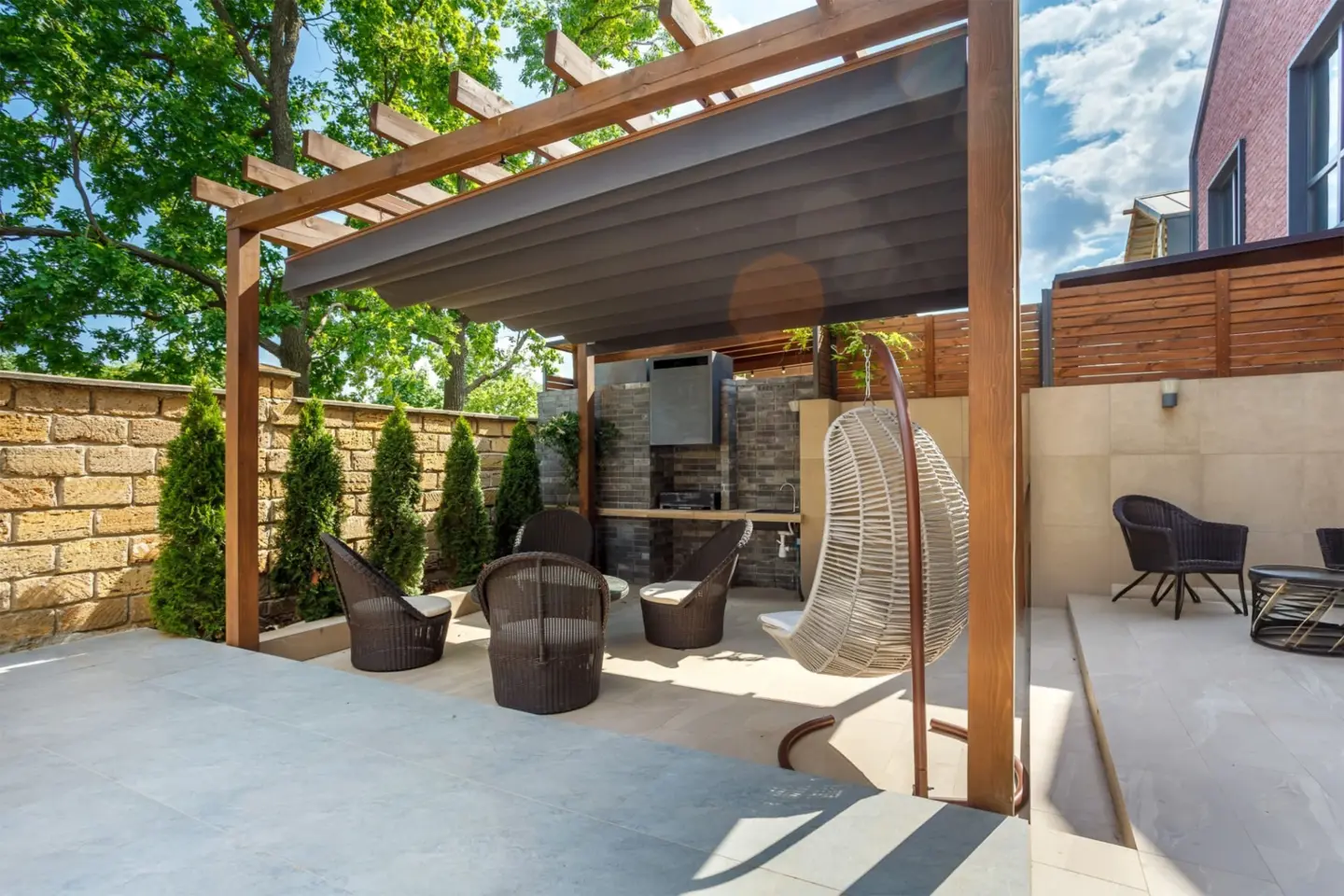 backyard-outdoor-living-bbq-zone-with-pergola-fireplace-and-big-wooden-fence-on-the-background-in-lincoln-ne