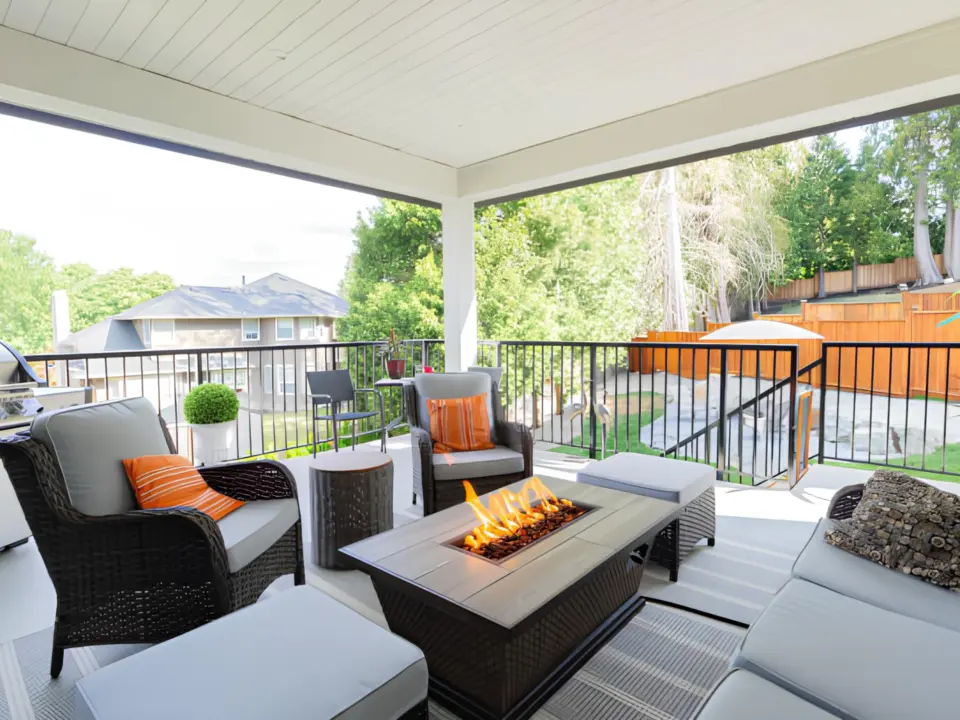 covered-deck-with-a-firepit-and-black-metal-railing-with-big-wooden-wall-fence-in-lincoln-ne