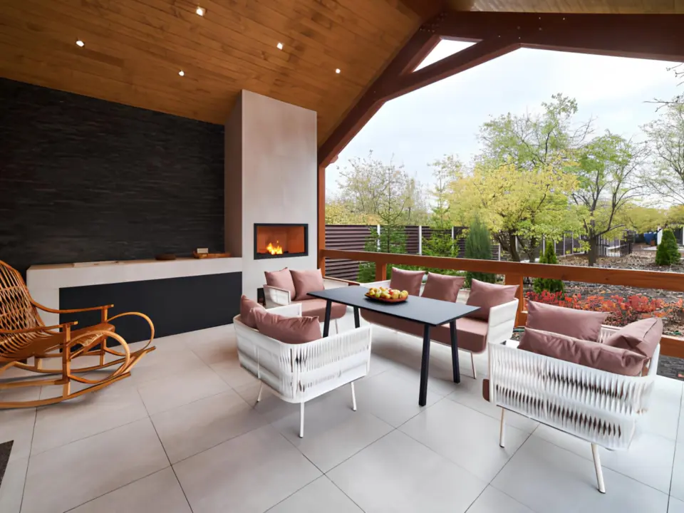 covered-deck-with-an-outdoor-living-room-featuring-a-fireplace-and-trees-on-the-background-in-lincoln-ne