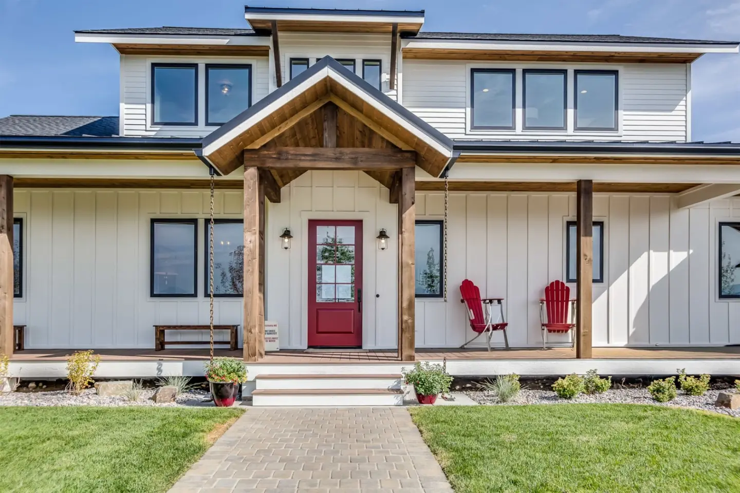 front-view-of-the-black-trim-windows-and-red-front-door-on-white-house-with-porch-in-lincoln-ne