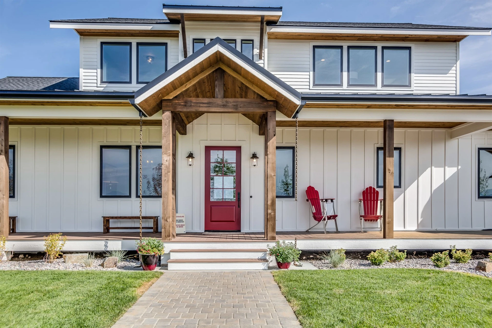 front-view-of-the-black-trim-windows-and-red-front-door-on-white-house-with-porch-in-lincoln-ne