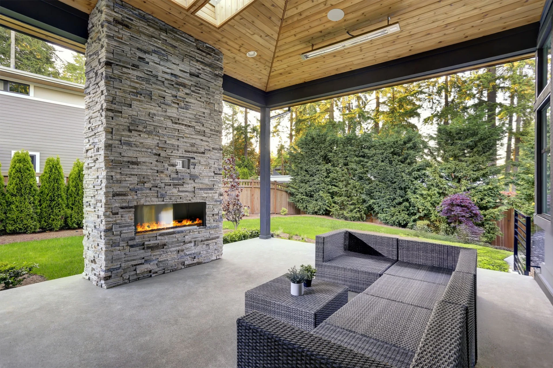new-modern-home-outdoor-living-features-a-backyard-with-patio-with-fireplace-and-a-wooden-wall-fence-in-lincoln-ne